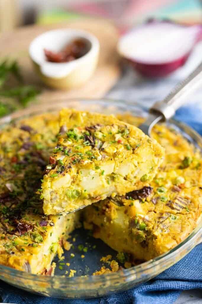 a slice of vegan quiche held up on a spatula