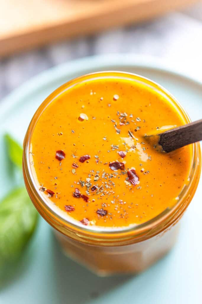 red pepper miso dressing in a storage jar topped with red pepper flakes