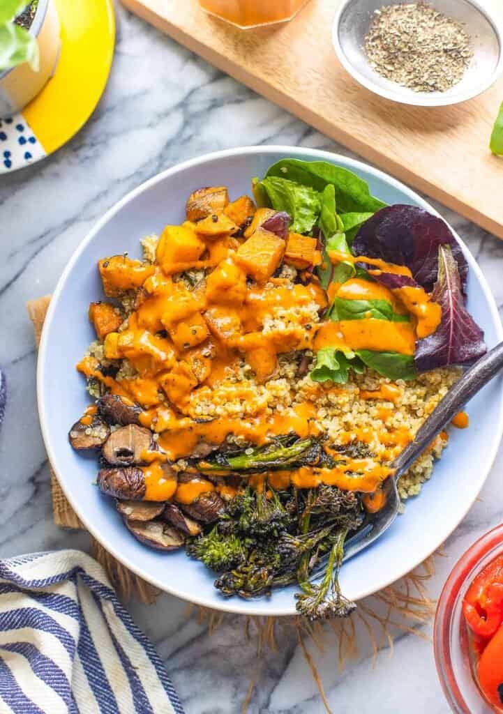 red pepper miso dressing drizzled over a bowl of roasted vegetables and quinoa