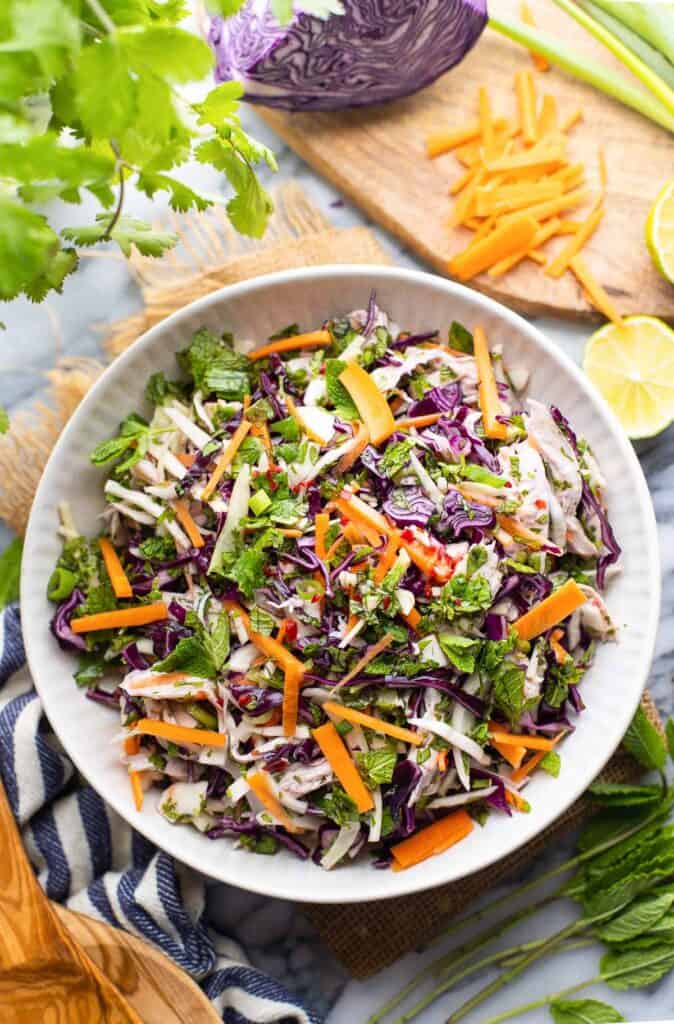 Vietnamese Chicken salad in a salad bowl surrounded by fresh ingredients