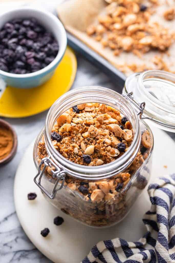 homemade grain free granola in a jars surrounded by the ingredients