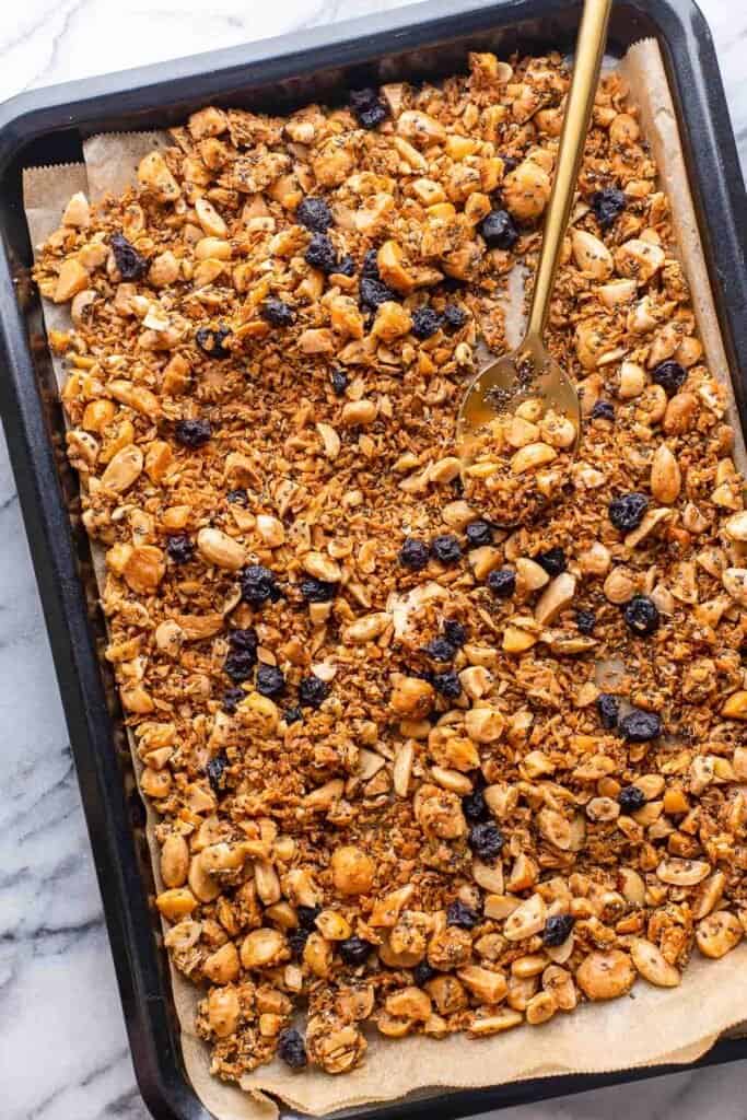 Grain Free Granola with dried blueberries on a baking sheet
