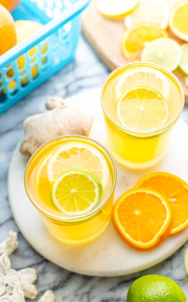 a couple of glasses of Homemade Electrolyte Drink garnished with lemon, lime and orange slices