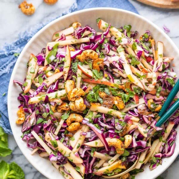 Apple and Red Cabbage Salad in a bowl with serving tongs