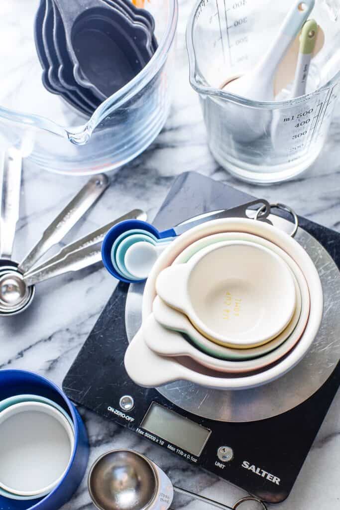 an assortment of measuring cups, spoons and kitchen scales