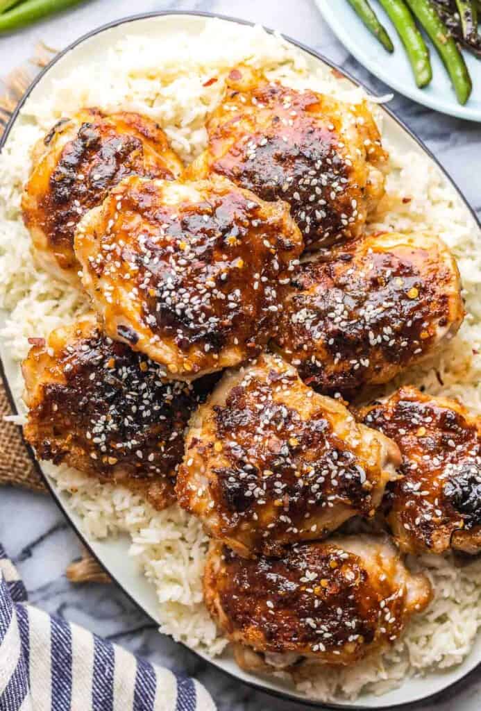 miso chicken thighs piled on a platter with rice