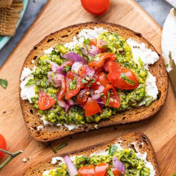 two pieces of Cilantro Lime Pesto Toast & Tomato Salsa on a serving board