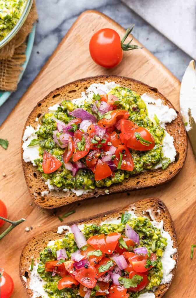 cilantro lime pesto toasted topped with a tomato salsa on a cutting board