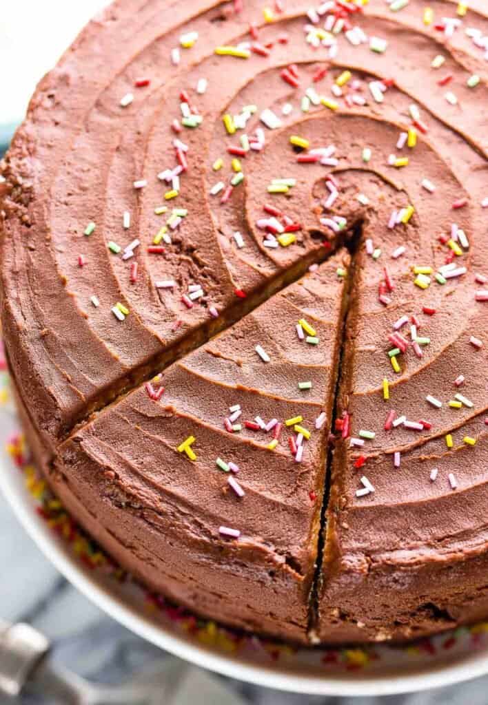 chocolate frosted vegan vanilla cake with sprinkles on top
