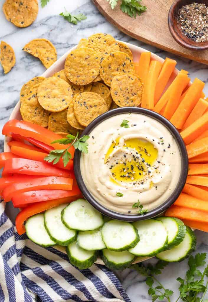 homemade hummus on a veggie platter with crackers