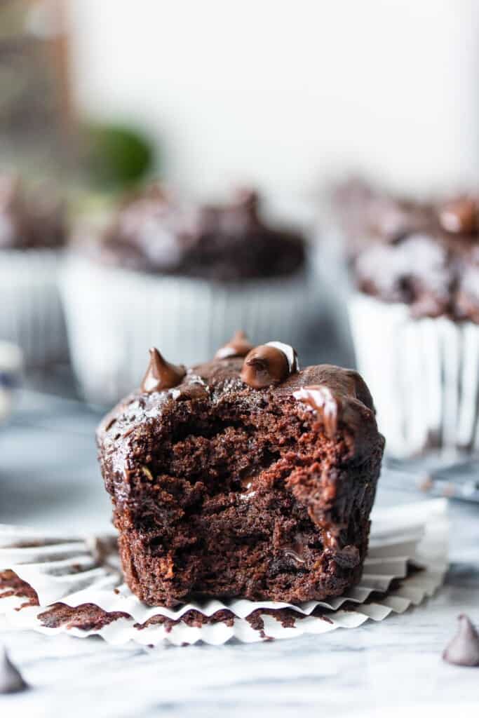 a Gluten Free Chocolate Zucchini Muffin with a bite taken out