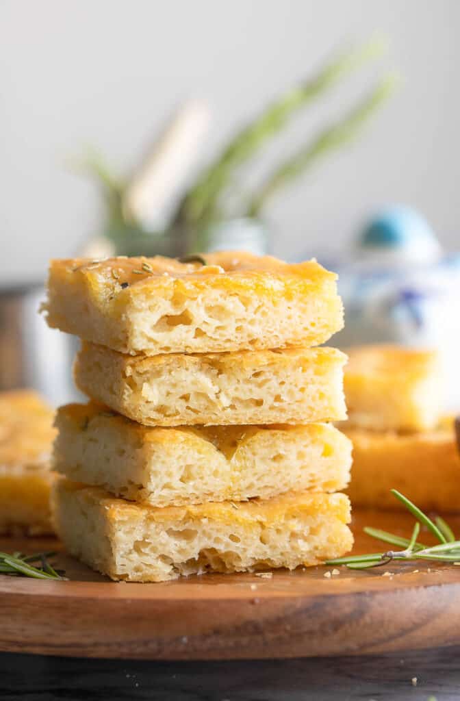 a stack of gluten free focaccia bread slices on a wooden plate