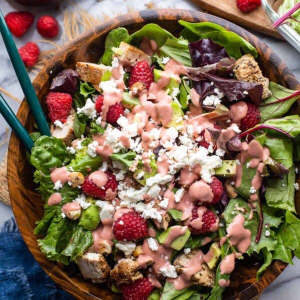 raspberry salad with chopped chicken, avocado, hazelnut and feta with a raspberry dressing on top