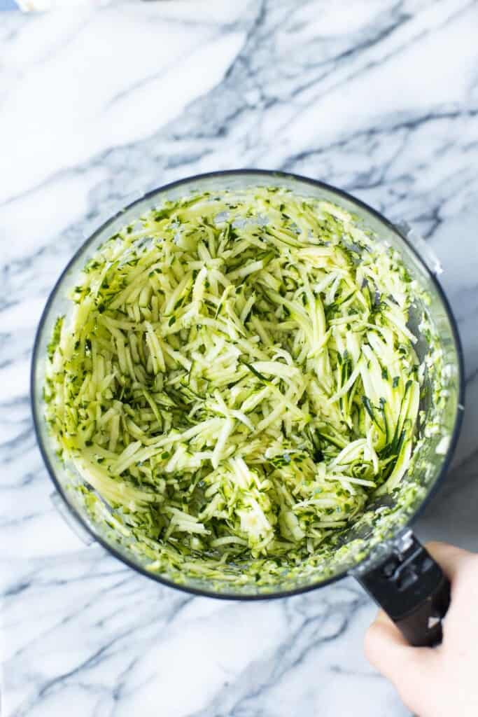 grated zucchini in a food processor bowl