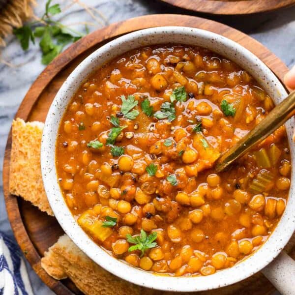 Curried Tomato Lentil Soup in a soup bowl with a side of bread