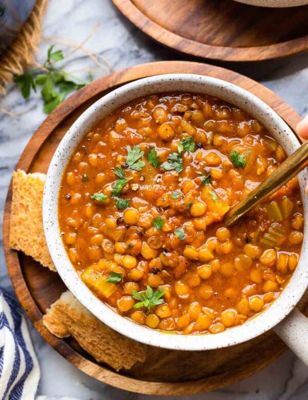 Curried Tomato Lentil Soup in a soup bowl with a side of bread