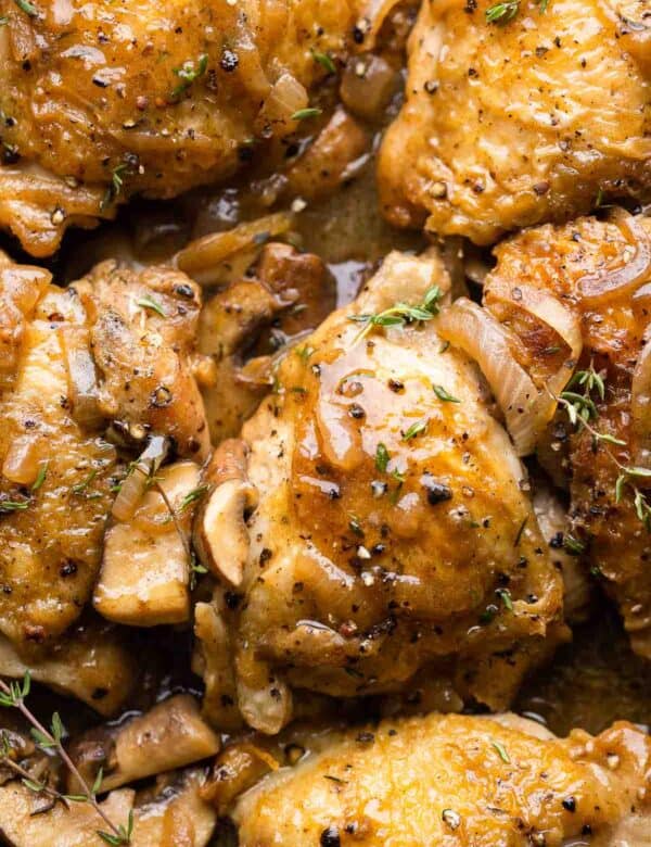 Apple Cider Braised Chicken Thighs topped with fresh thyme