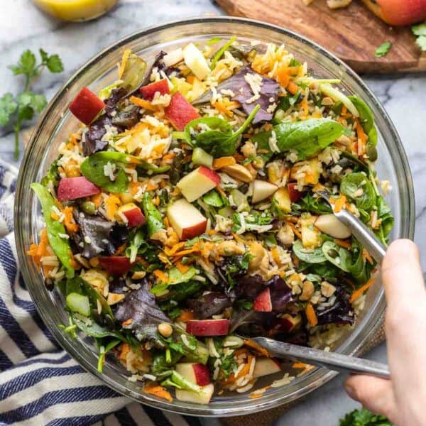 fall rice salad in a mixing bowl with tongs