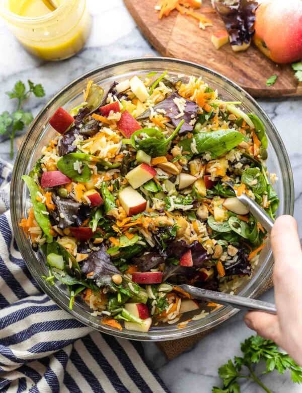 fall rice salad in a mixing bowl with tongs