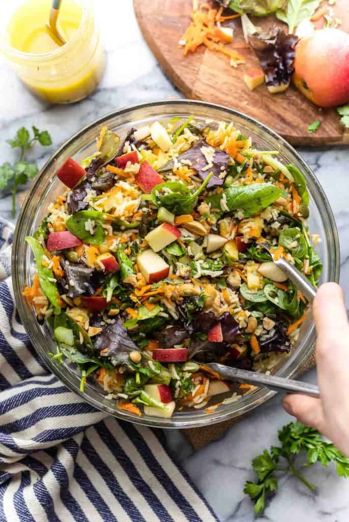 fall rice salad in a mixing bowl with tongs