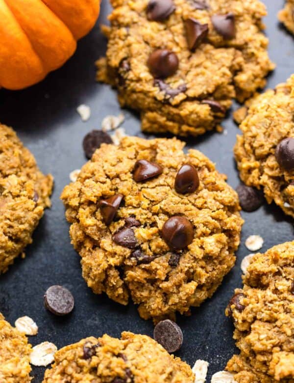 healthy oatmeal pumpkin cookies with chocolate chips on a baking sheet sprinkled with oats