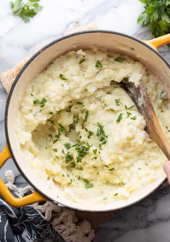 Mashed Potatoes with Cauliflower in a large pot with a serving spoon

