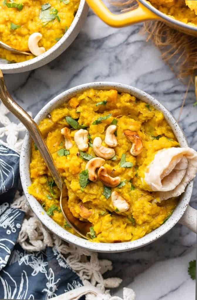 lentil dahl in a bowl with rolled up chapti