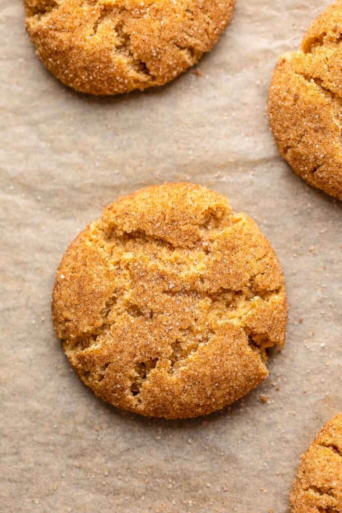 a freshly baked pumpkin snickerdoodle cookie on a baking sheet