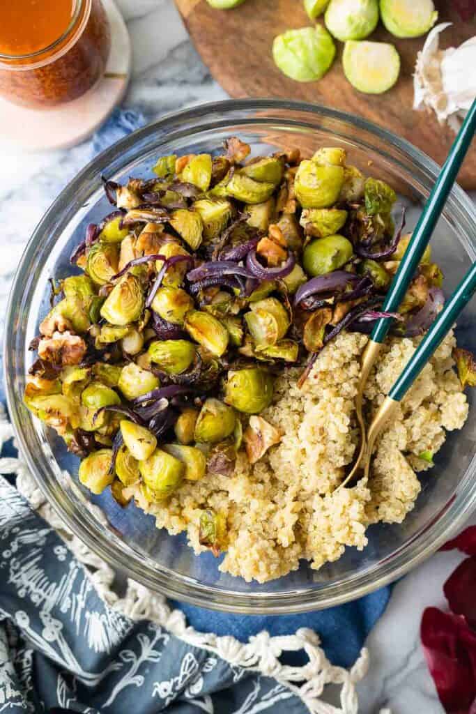 cooked quinoa, roasted brussels sprouts and onions slices in a large mixing bowl