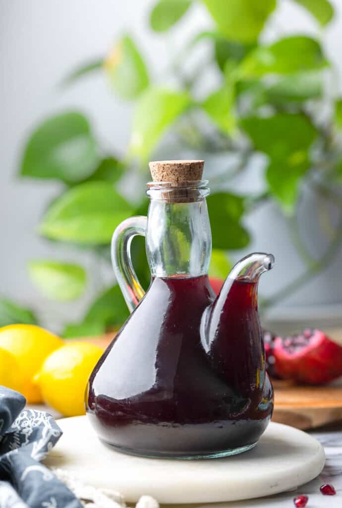 a glass, corked bottle full of Homemade Grenadine Syrup