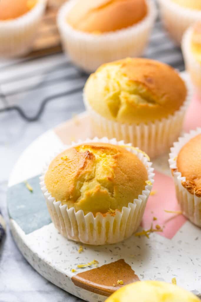 Gluten Free lemon muffins on a serving platter topped with lemon zest