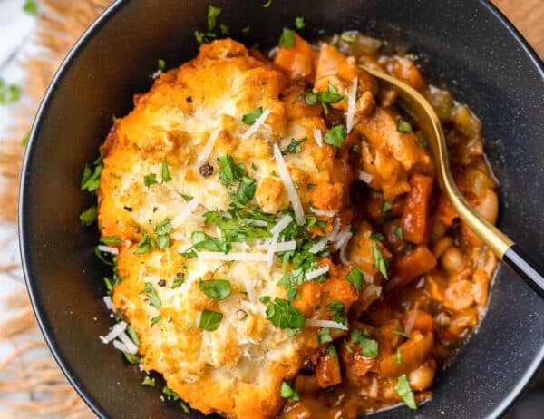 italian chicken white bean stew in a bowl with a gluten free parmesan biscuit