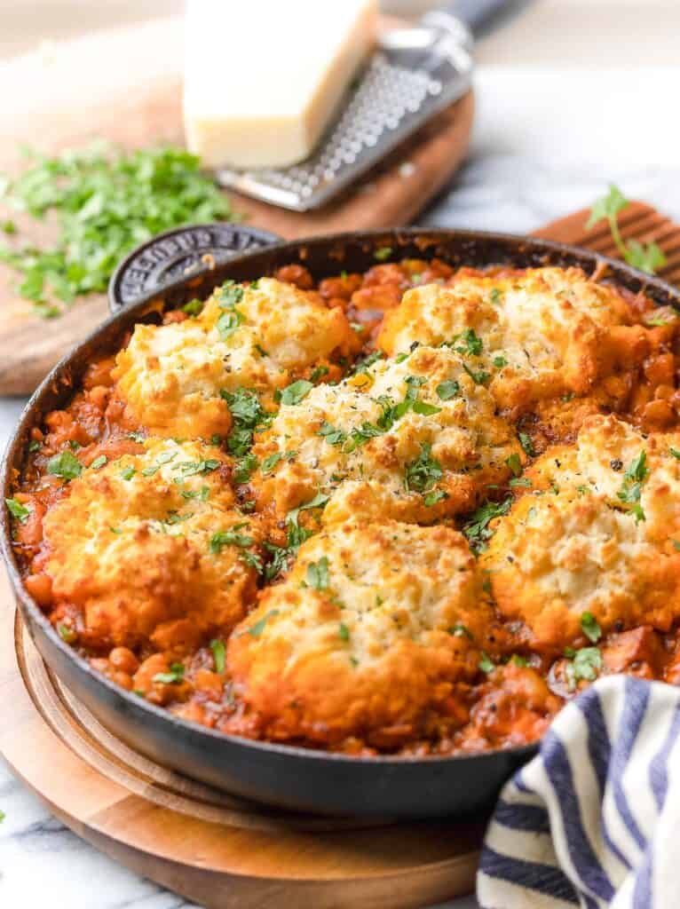 Italian Chicken Cobbler in a cast iron pan topped with chopped parsley 