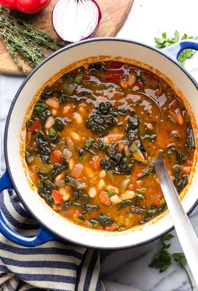 Spanish Chorizo and White Bean Soup in a pot with a kitchen towel underneath