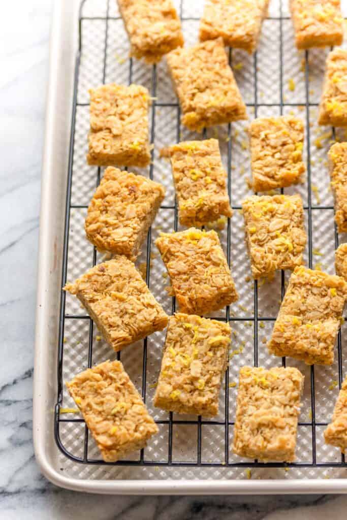 Lemon Ginger Flapjacks sliced into bite sized portions laying on a cooling rack