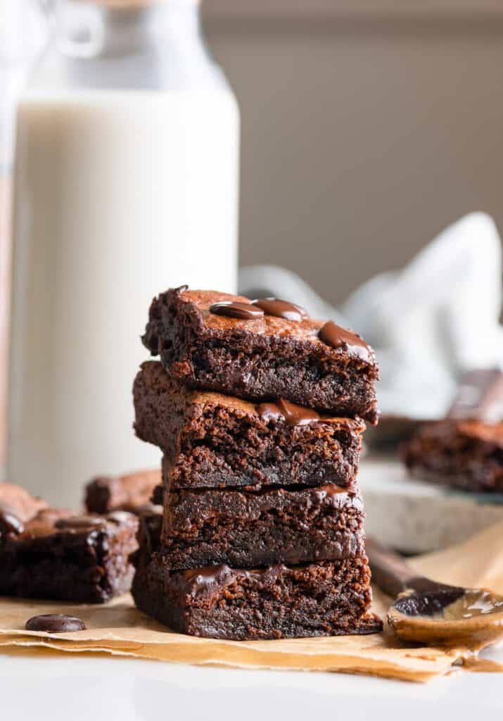 a stack of Almond Butter Flourless Brownies with a spoon full of almond butter 