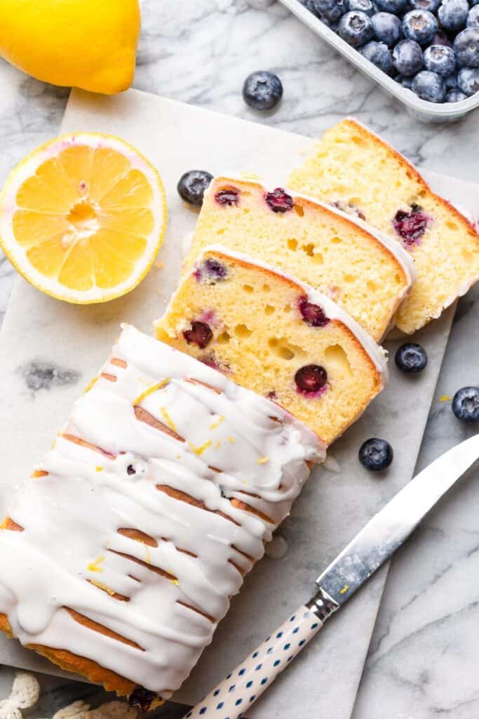 Gluten Free Blueberry Lemon Loaf on a marble surface with three slices cut into the loaf