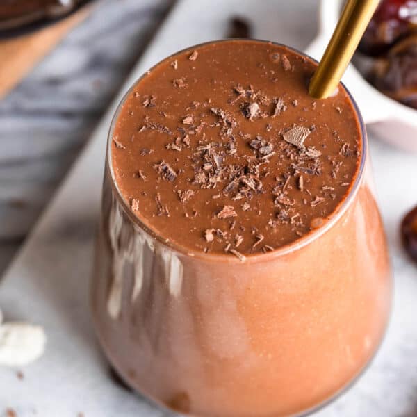 chocolate coffee smoothie in a glass topped with chocolate shavings