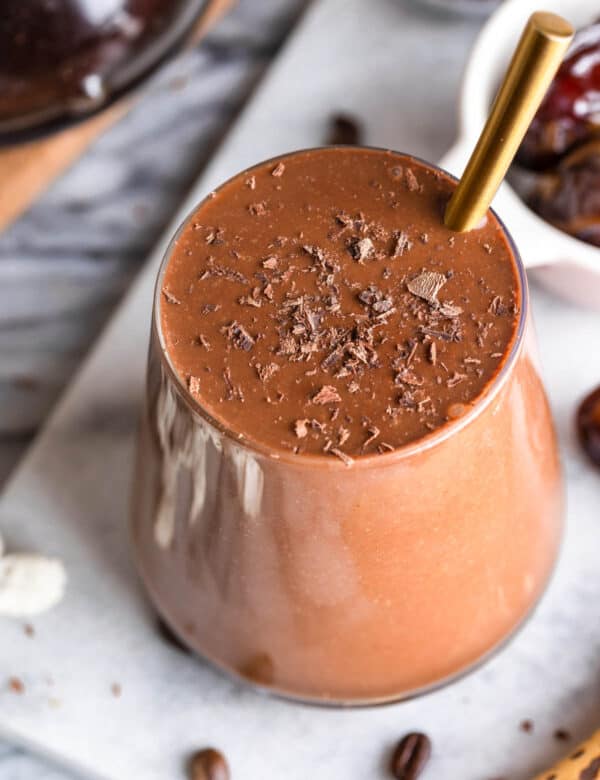 chocolate coffee smoothie in a glass topped with chocolate shavings