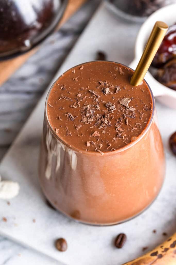 chocolate coffee smoothie in a glass topped with chocolate shavings