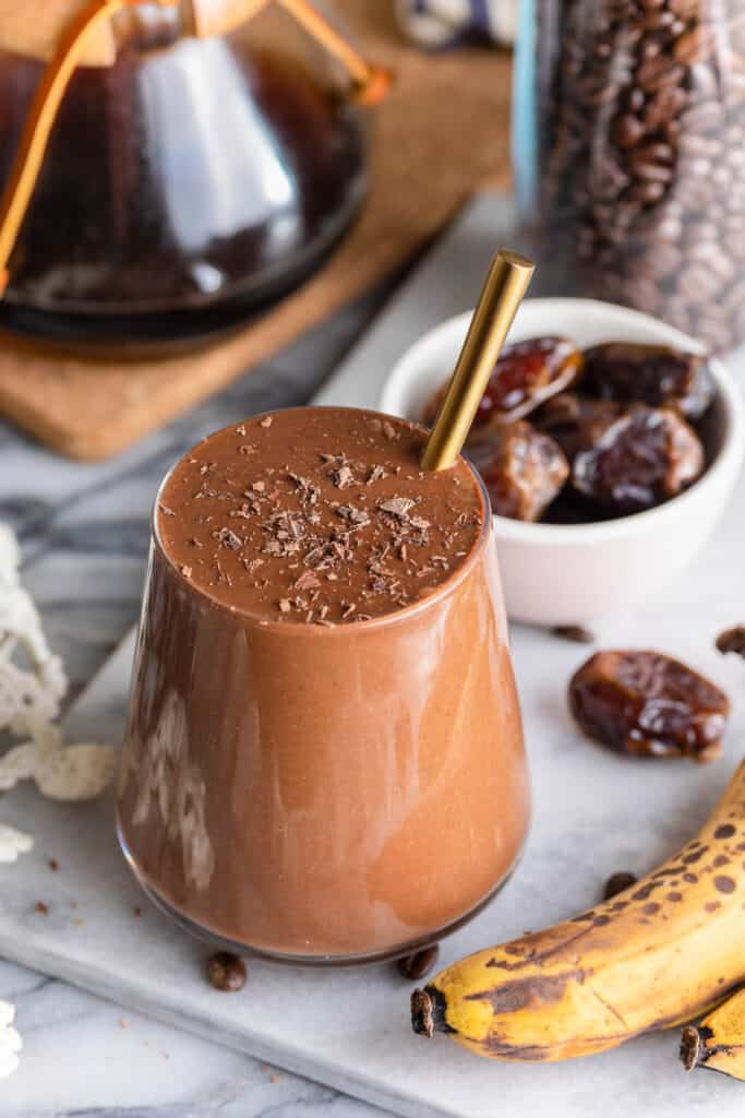chocolate coffee smoothie in a glass cup with a straw
