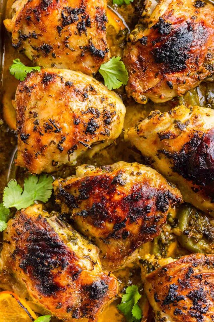 baked mojo chicken thighs with blackened skin and fresh cilantro
