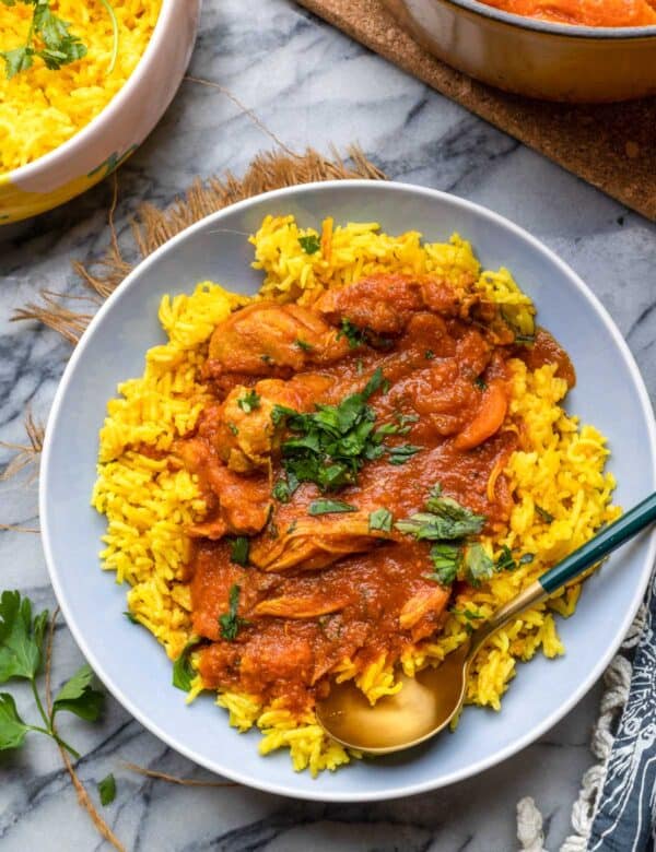 Moroccan Chicken Stew served over a bed of curried rice with parsley on top.