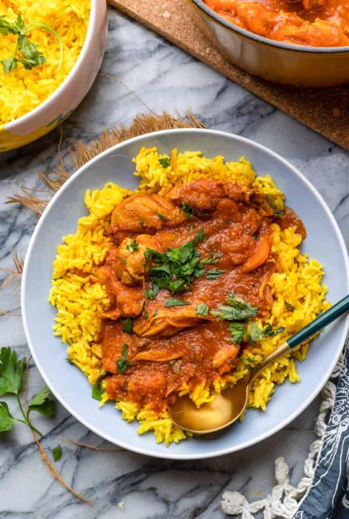 Moroccan Chicken Stew served over a bed of curried rice with parsley on top.