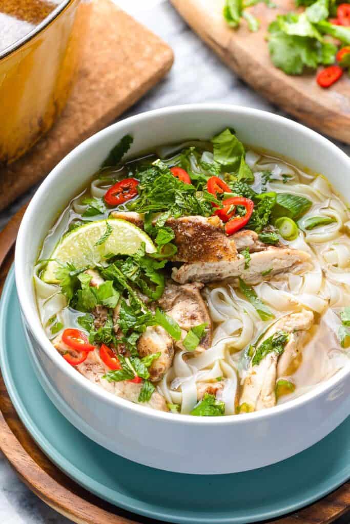 Five Spice Chicken Noodle Soup with fresh mint, cilantro, chili and lime wedge 
