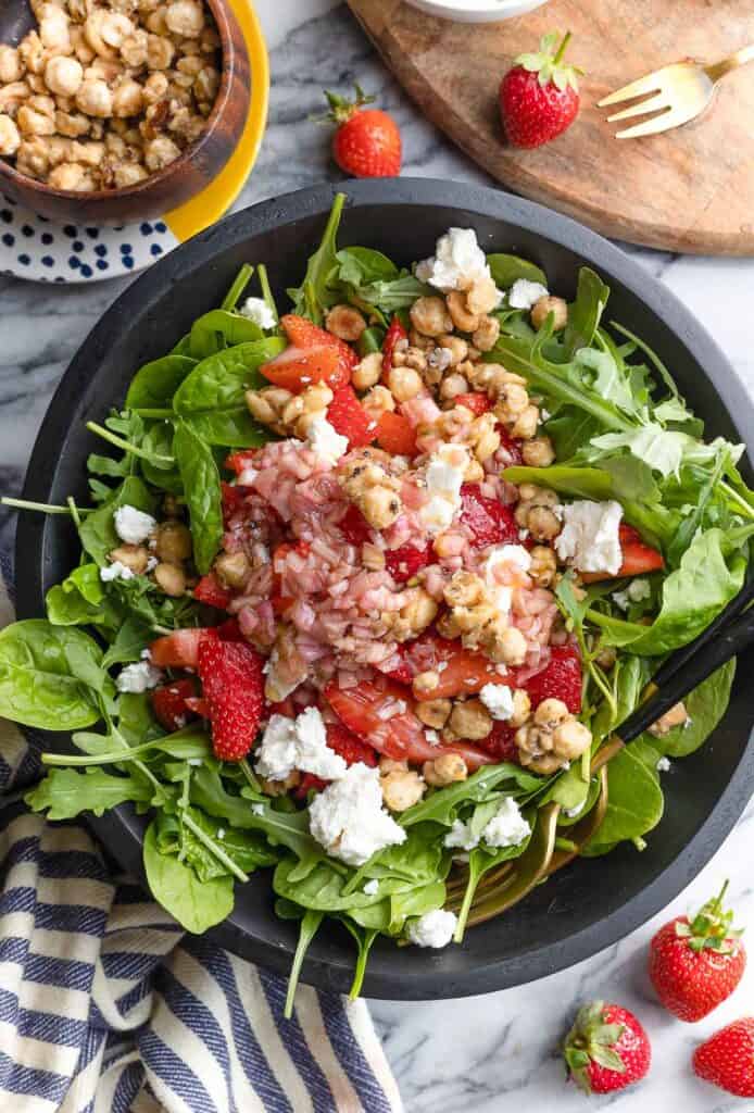 Strawberry Feta Salad with Candied Hazelnuts and crumbled feta in a bed of spinach and arugula leaves 