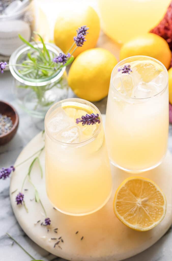 two glass of iced Lavender Lemonade with a slice of lemon and lavender flower in the glass