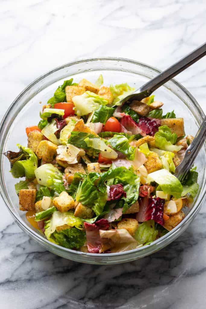 Lemon & Garlic BLT Salad  in a mixing bowl with salad tongs