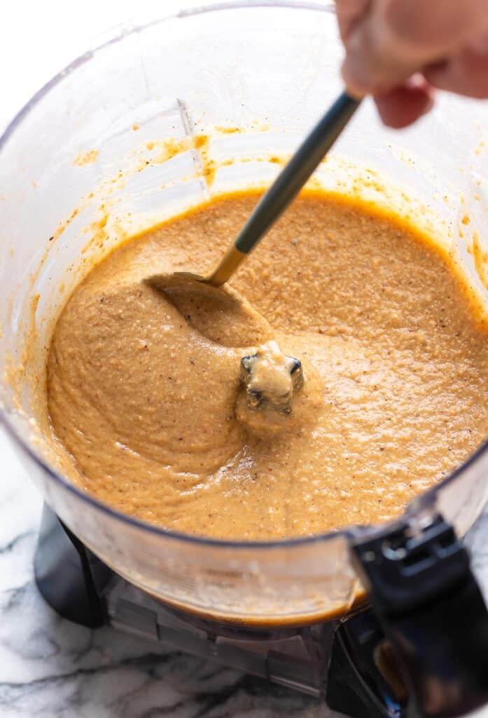 a spoon stirring Homemade Hazelnut Butter in a food processor