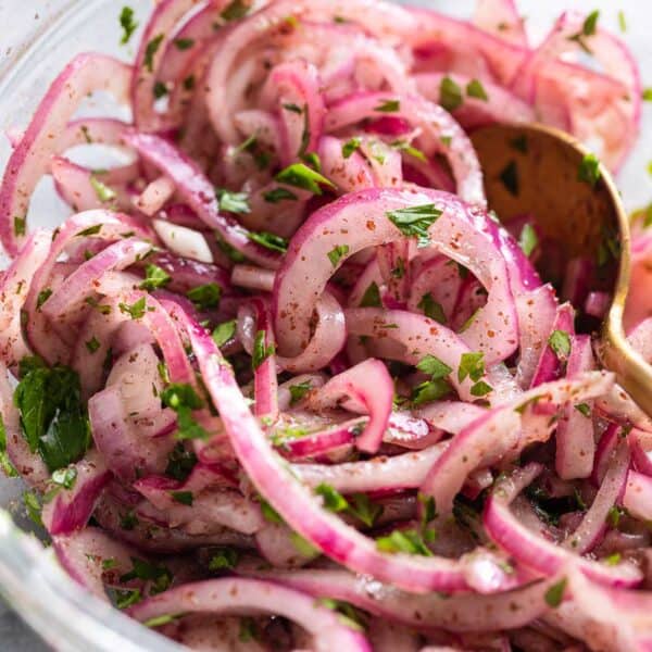 a bowl of thinly Sumac Onions - thinly sliced red onions mixed with sumac and parsley